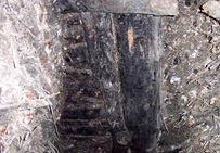 Éléments de boisage et accumulation de copeaux de bois dans une galerie de mine antique en cours de fouille.